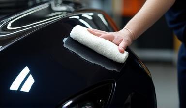 Car body being polished with a soft cloth